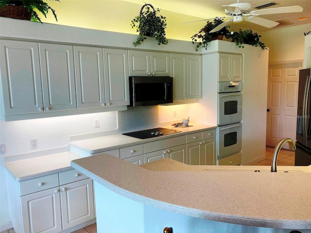 kitchen featuring black appliances, ceiling fan, white cabinetry, and light tile patterned floors