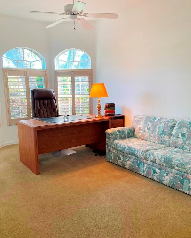 carpeted office space with ceiling fan