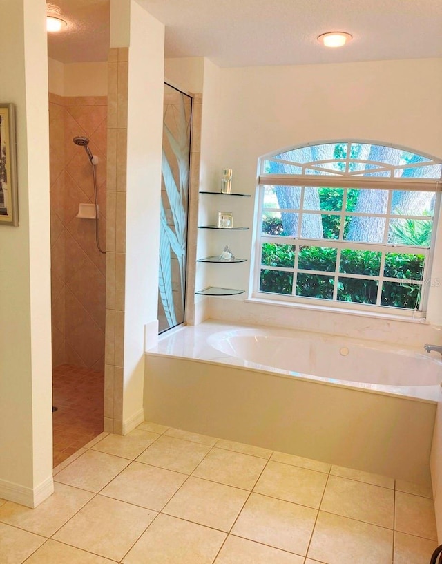 bathroom with tile patterned flooring, shower with separate bathtub, and a textured ceiling