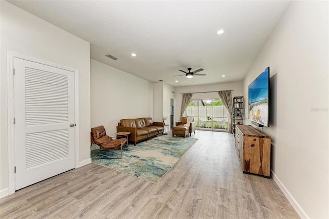 living room with ceiling fan and light hardwood / wood-style flooring