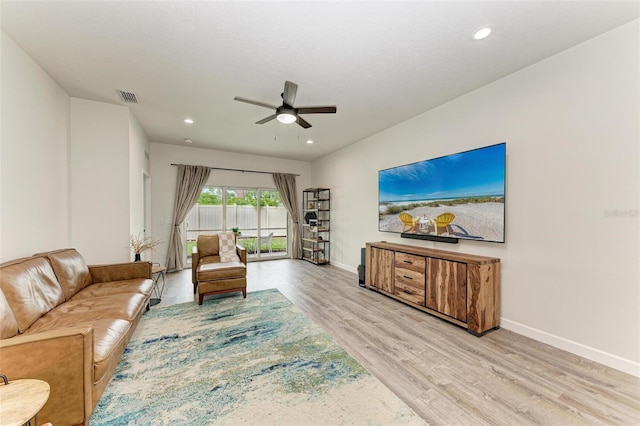 living room with light wood-type flooring and ceiling fan