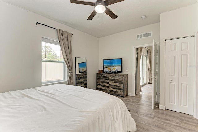 bedroom featuring ceiling fan, light hardwood / wood-style floors, and a textured ceiling