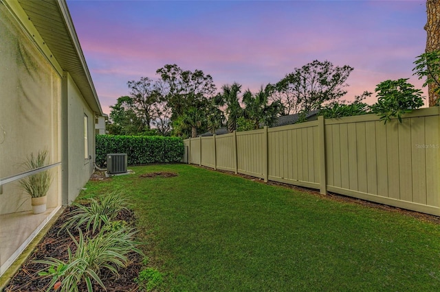 yard at dusk featuring central air condition unit