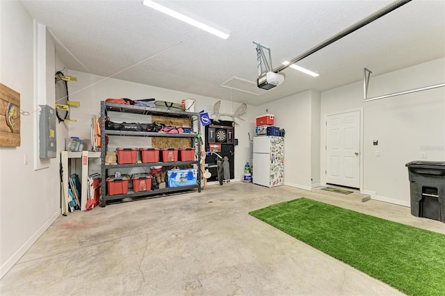 garage featuring white refrigerator, a garage door opener, and electric panel