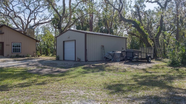 view of outdoor structure featuring a garage and a yard