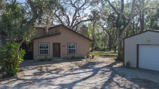 ranch-style house featuring a garage and an outbuilding