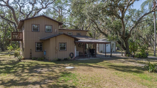 rear view of house with a patio and a lawn