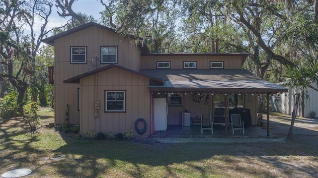 rear view of property featuring a yard and a patio