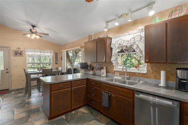 kitchen with sink, stainless steel dishwasher, kitchen peninsula, lofted ceiling, and decorative backsplash