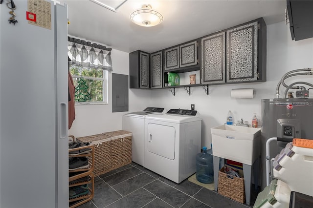 clothes washing area featuring cabinets, water heater, electric panel, washer and clothes dryer, and dark tile patterned flooring