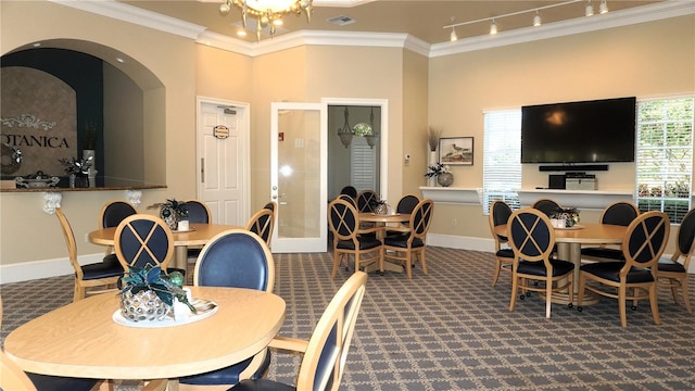 dining area with carpet, crown molding, and a healthy amount of sunlight