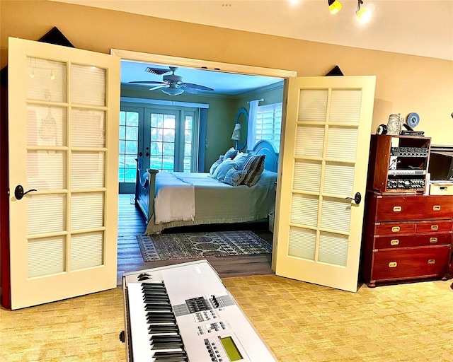 bedroom with french doors and light hardwood / wood-style flooring