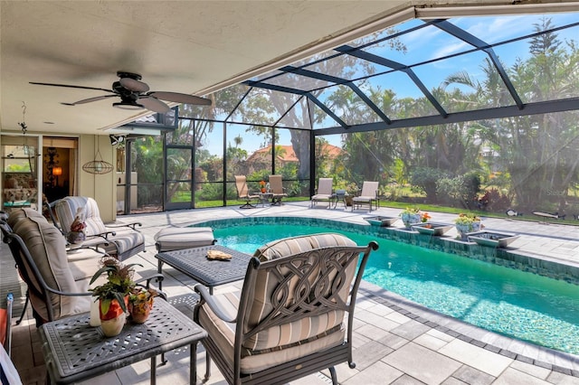 view of swimming pool with a patio area, ceiling fan, and glass enclosure