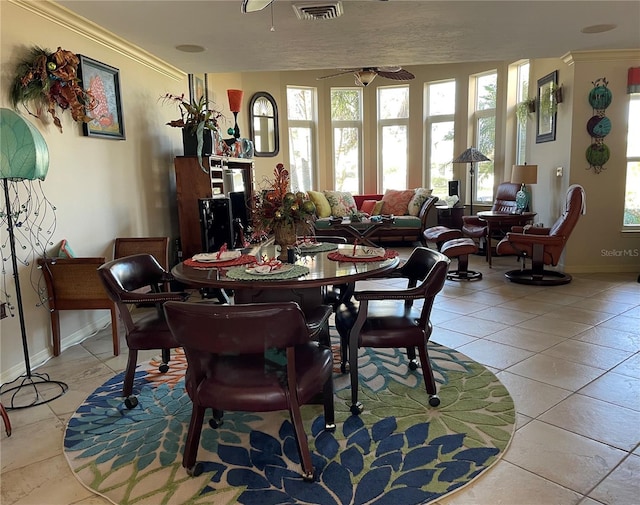 dining space featuring ceiling fan, light tile patterned floors, ornamental molding, and a wealth of natural light