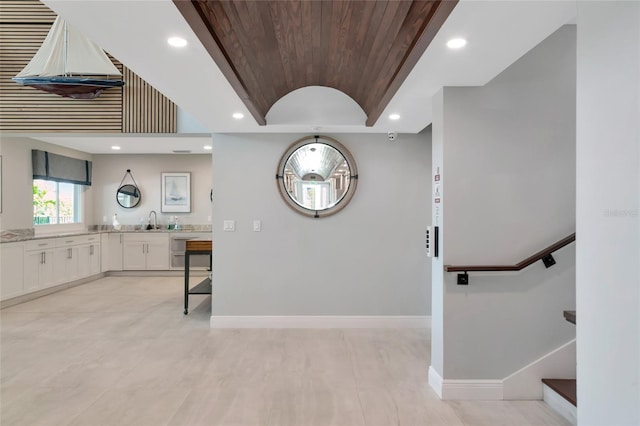 kitchen with white cabinetry, sink, and wooden ceiling