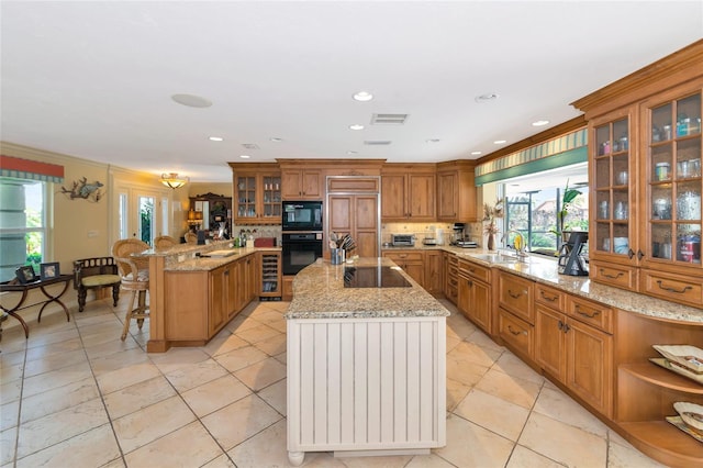 kitchen featuring a kitchen island, plenty of natural light, crown molding, and black appliances