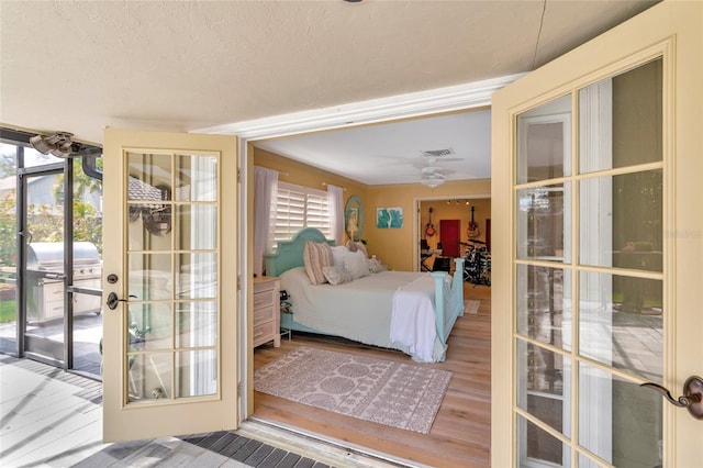 bedroom featuring hardwood / wood-style floors, a textured ceiling, and access to outside