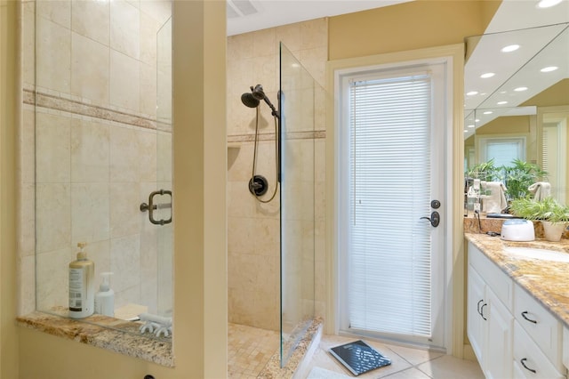 bathroom featuring tile patterned floors, vanity, and tiled shower