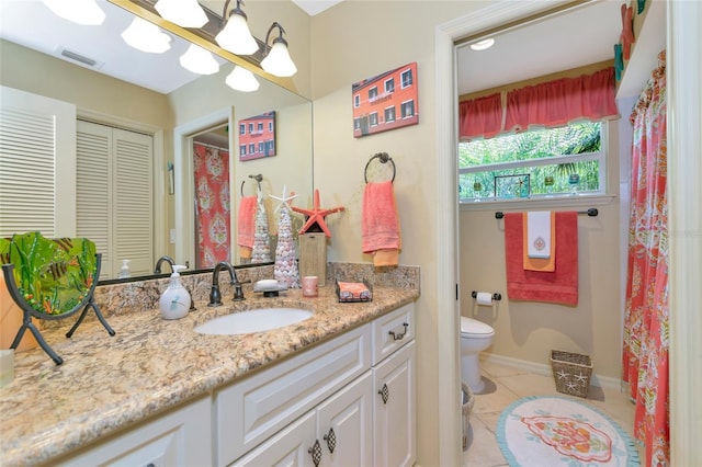 bathroom featuring tile patterned flooring, vanity, and toilet