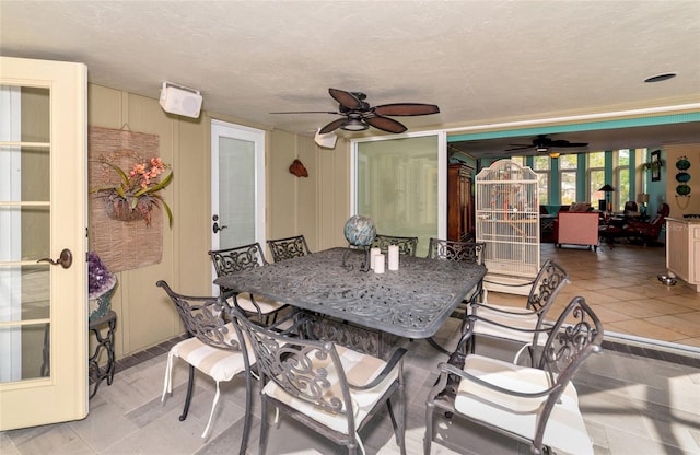 dining space with light tile patterned floors, a textured ceiling, french doors, and ceiling fan