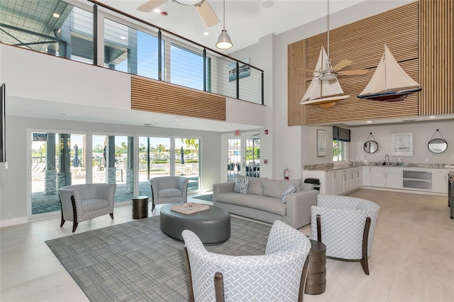 living room with plenty of natural light, ceiling fan, french doors, and a high ceiling