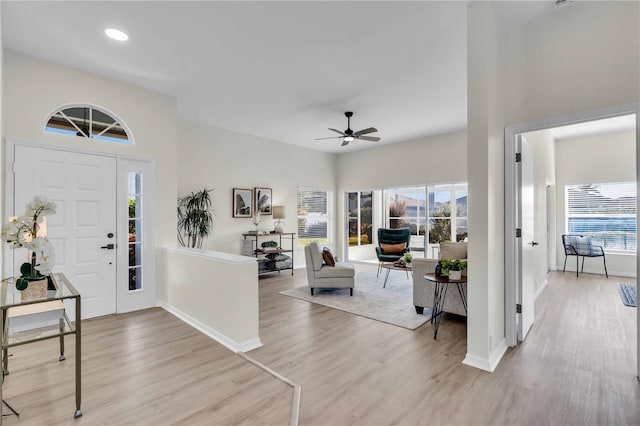 foyer entrance featuring ceiling fan, a healthy amount of sunlight, and light wood-type flooring