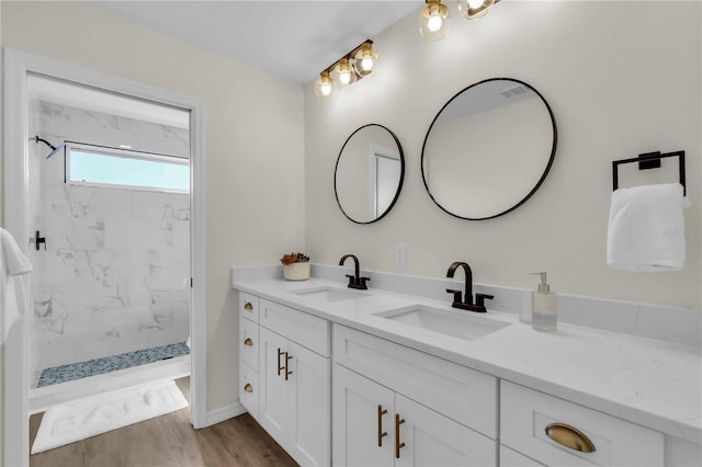 bathroom featuring tiled shower, vanity, and hardwood / wood-style flooring