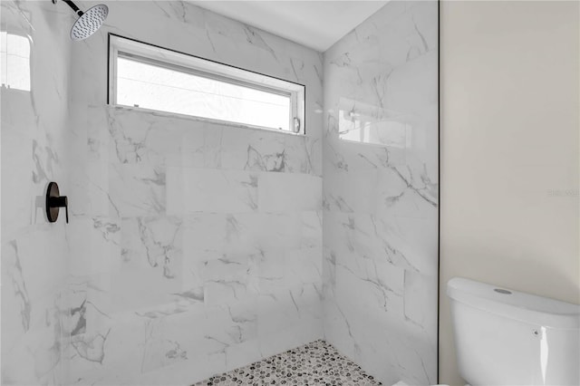 bathroom featuring toilet and tiled shower