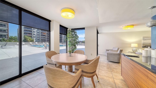 dining area featuring light tile patterned flooring and a wall of windows