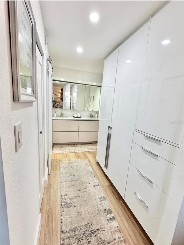 interior space featuring a shower with shower door, hardwood / wood-style floors, and vanity