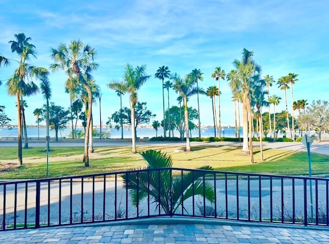 view of swimming pool with a water view and a lawn