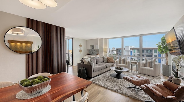 living room featuring a wall of windows and light hardwood / wood-style flooring