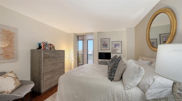 bedroom with access to outside, dark hardwood / wood-style floors, and expansive windows