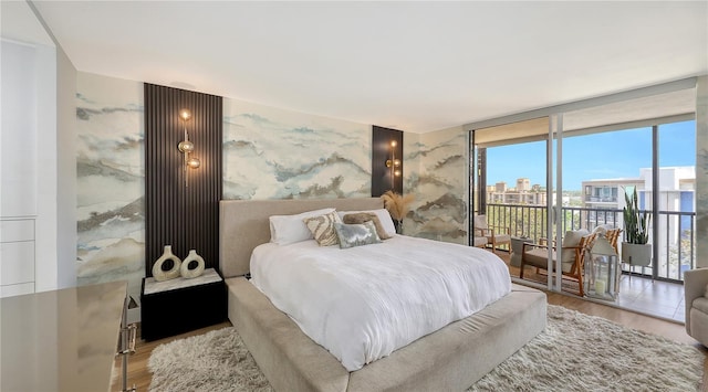 bedroom featuring floor to ceiling windows and hardwood / wood-style flooring