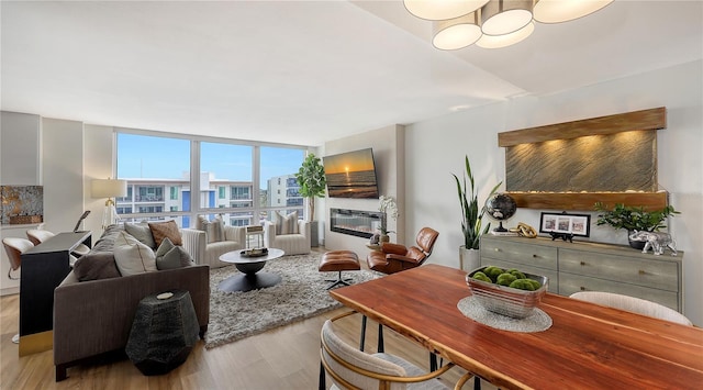 living room with expansive windows and light hardwood / wood-style flooring