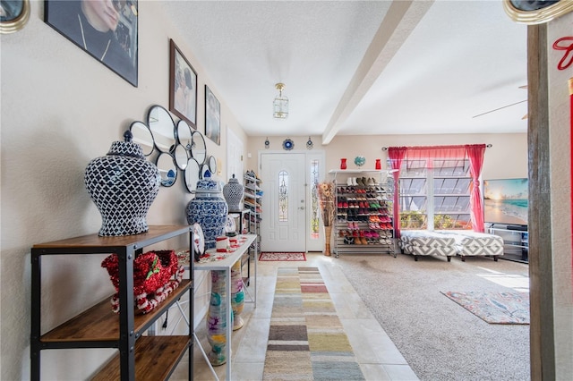 carpeted foyer with beam ceiling