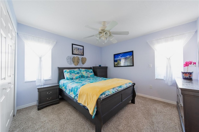 carpeted bedroom with ceiling fan and a closet