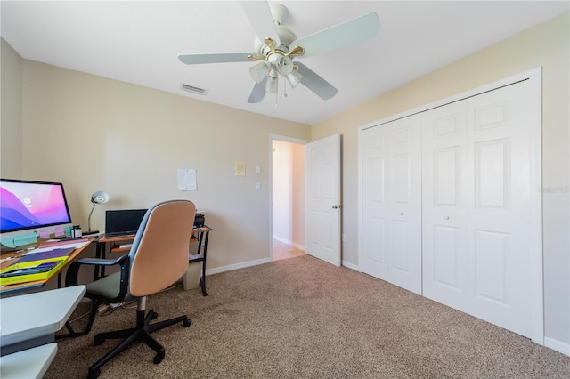 carpeted office space featuring ceiling fan