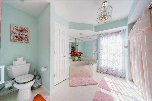 bathroom featuring a notable chandelier, toilet, and a bath