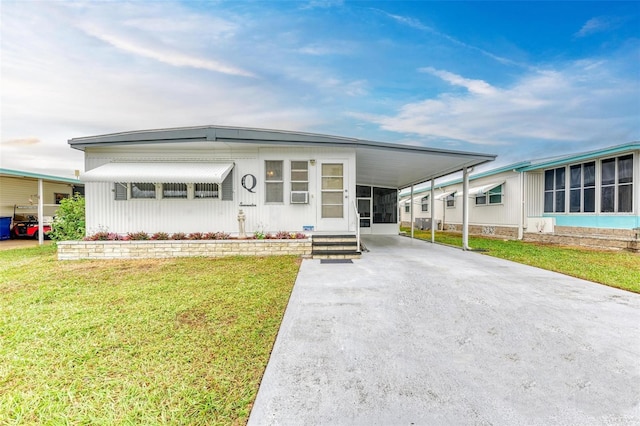 manufactured / mobile home with a front yard and a carport