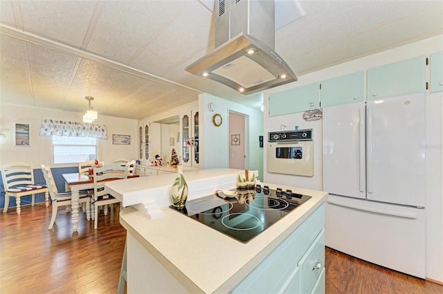 kitchen featuring hanging light fixtures, dark hardwood / wood-style floors, island exhaust hood, white appliances, and a kitchen island