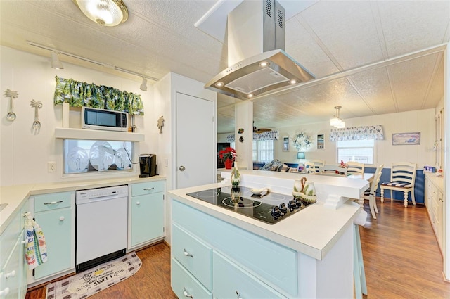 kitchen with island exhaust hood, white dishwasher, black electric cooktop, hardwood / wood-style flooring, and white cabinets