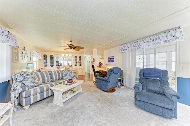 carpeted living room with ceiling fan and a textured ceiling