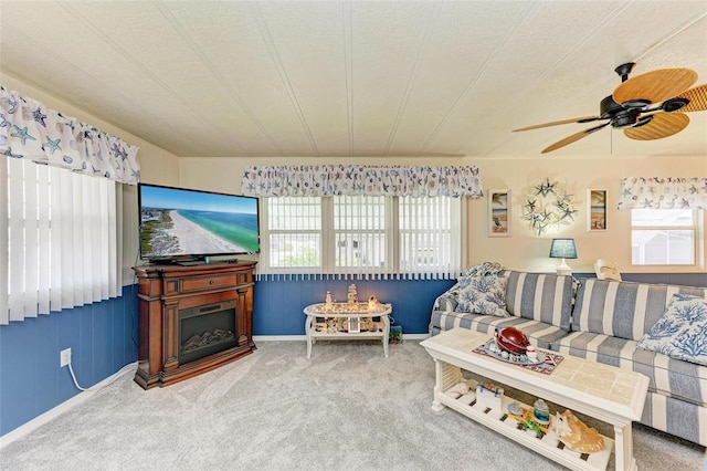 carpeted living room with a textured ceiling, ceiling fan, and a healthy amount of sunlight