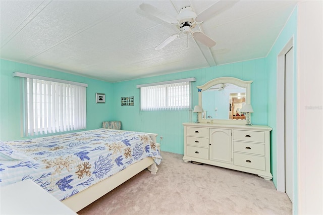 carpeted bedroom with ceiling fan and a textured ceiling