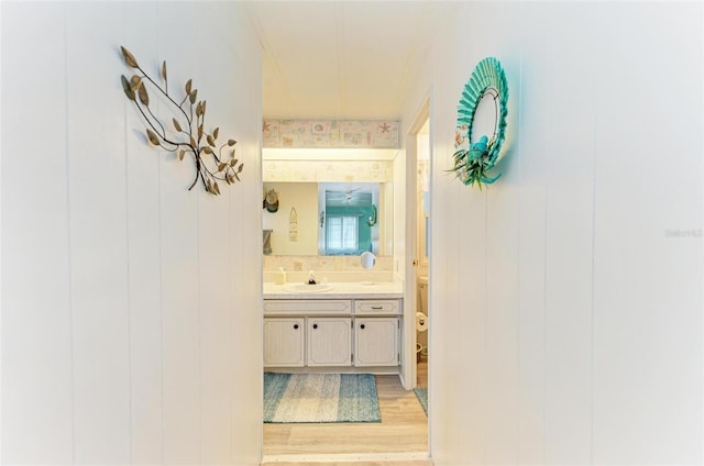 hallway with light hardwood / wood-style floors and sink