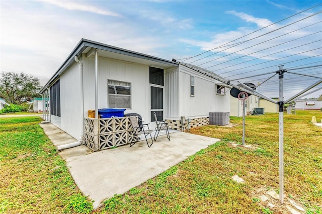 back of property featuring central air condition unit, a patio area, and a yard