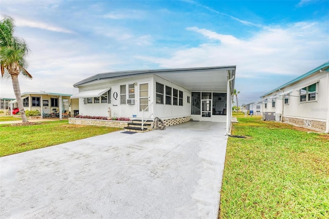 view of front of house featuring central air condition unit, a front lawn, and a carport