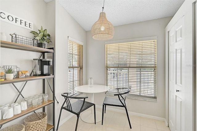 dining space featuring a textured ceiling and light tile patterned flooring