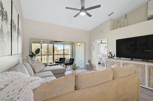 living room with high vaulted ceiling and light wood-type flooring